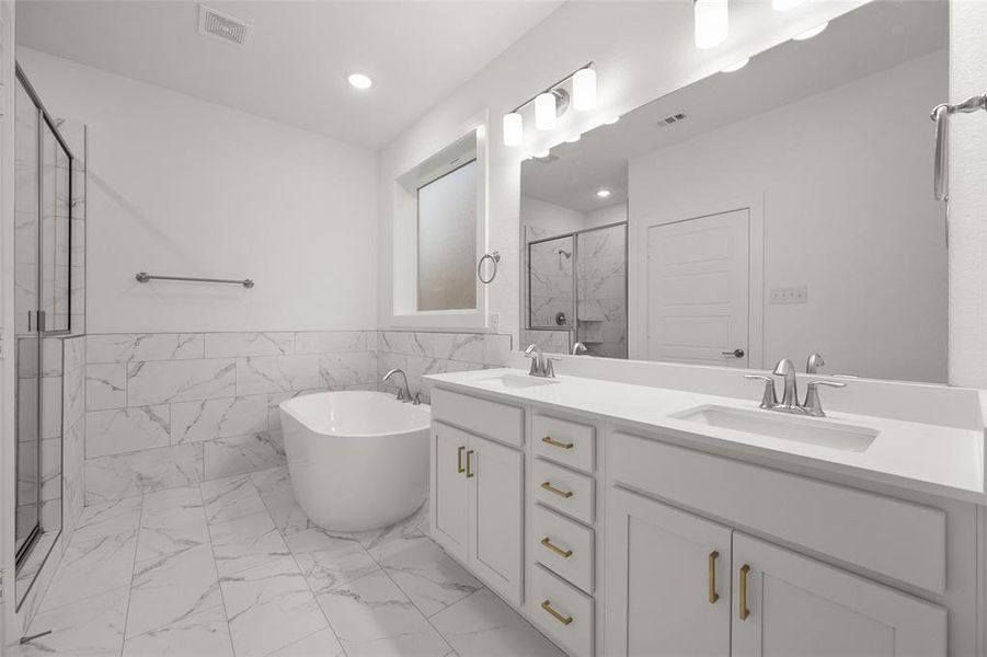 Primary bathroom with two sinks, tile floors, and a separate shower and tub.