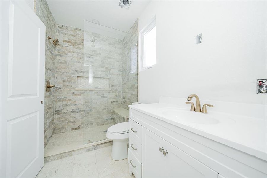Bathroom featuring vanity and a tile shower