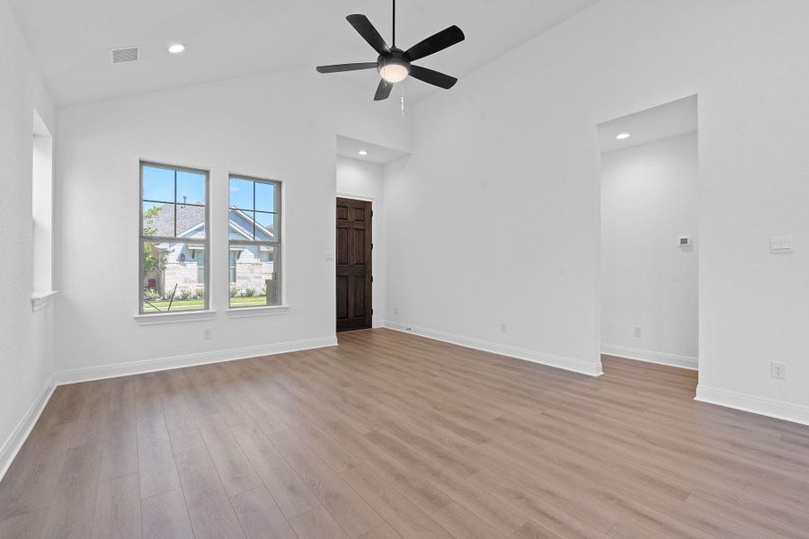 Unfurnished living room with light wood finished floors, high vaulted ceiling, recessed lighting, and ceiling fan