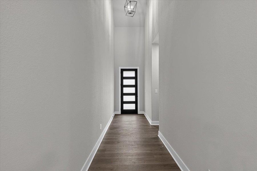 A long, inviting entryway welcomes you into this home, featuring high ceilings and modern wood flooring. A long, inviting entryway welcomes you into this home, featuring high ceilings and modern wood flooring.