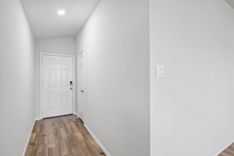 Entryway featuring wood-finish flooring, recessed lighting, and a paneled door with smart lock hardware
