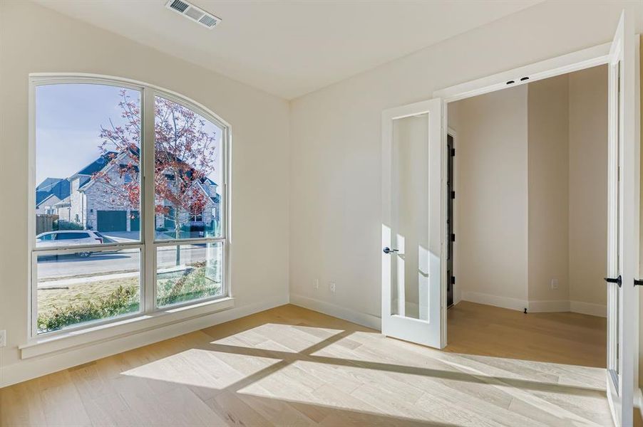 Unfurnished bedroom featuring light wood-style floors and french doors