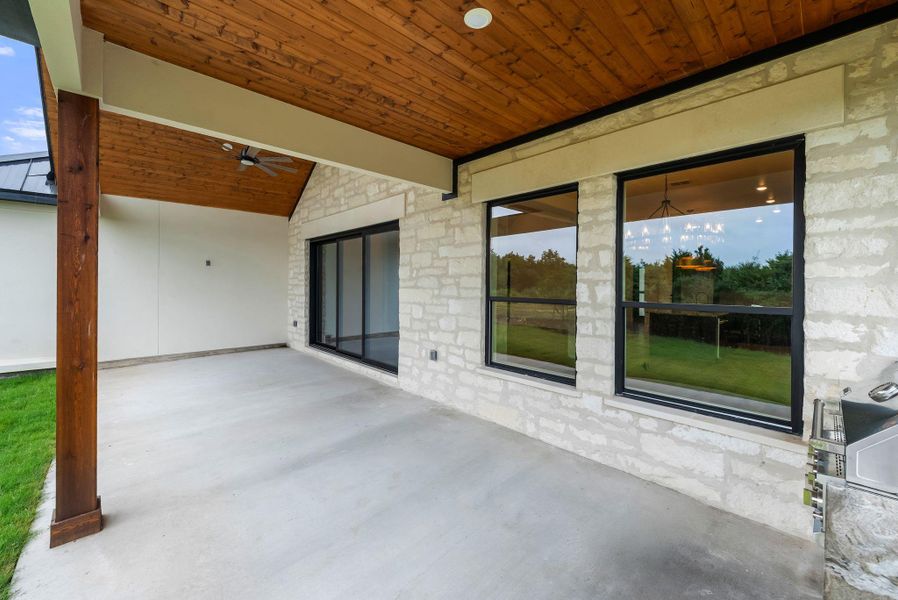 An inviting covered patio offers ample space for outdoor living, featuring an integrated grilling station.