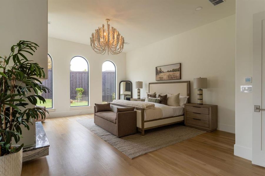 Bedroom with light wood finished floors and a chandelier