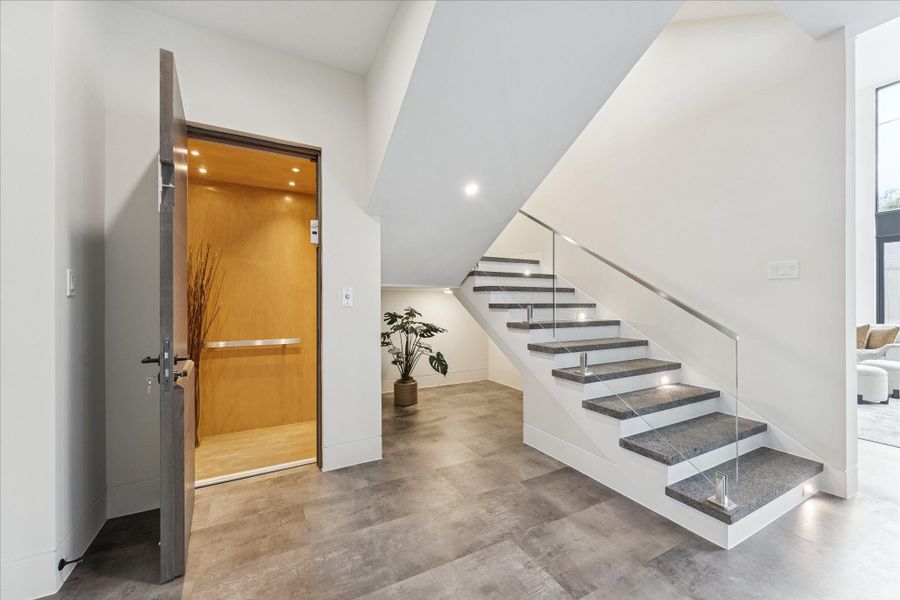 Ultimate convenience with an elevator servicing all three floors, complemented by a striking staircase featuring elegant volcanic stone floors.