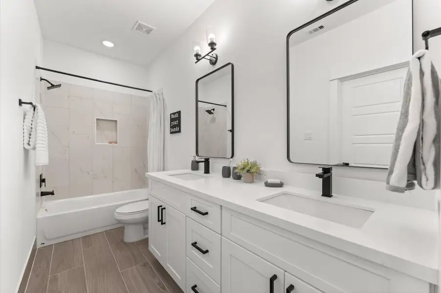 Beautifully appointed Jack and Jill bathroom nestled between the two secondary bedrooms on the first floor, designed to balance style and functionality. Each bedroom enjoys private access to the shared space, which features a sleek tub-shower combo—perfect for both quick rinses and relaxing soaks. Beautifully appointed Jack and Jill bathroom nestled between the two secondary bedrooms on the first floor, designed to balance style and functionality. Each bedroom enjoys private access to the shared space, which features a sleek tub-shower combo—perfect for both quick rinses and relaxing soaks.