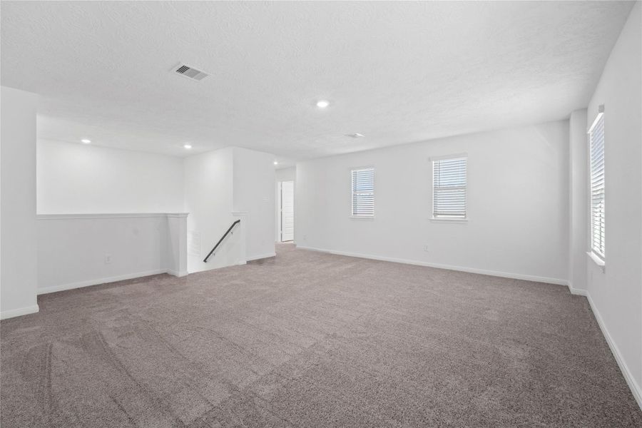Additional view from the game room looking towards staircase and secondary bedrooms and bathroom to the right.