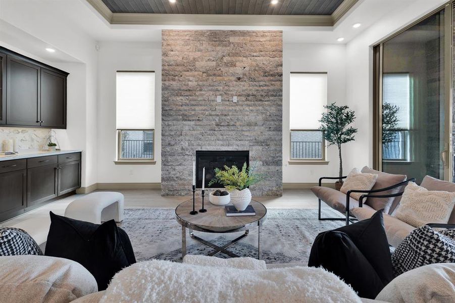 Living area featuring light wood-style flooring, recessed lighting, a fireplace, and ornamental molding