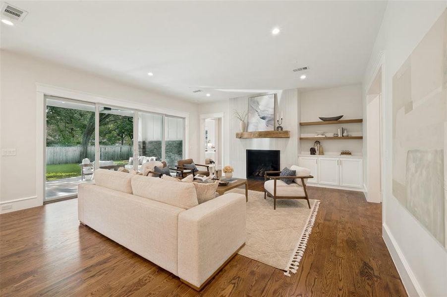 Spacious living area featuring wood-finish flooring, recessed lighting, and expansive sliding glass doors opening to the exterior