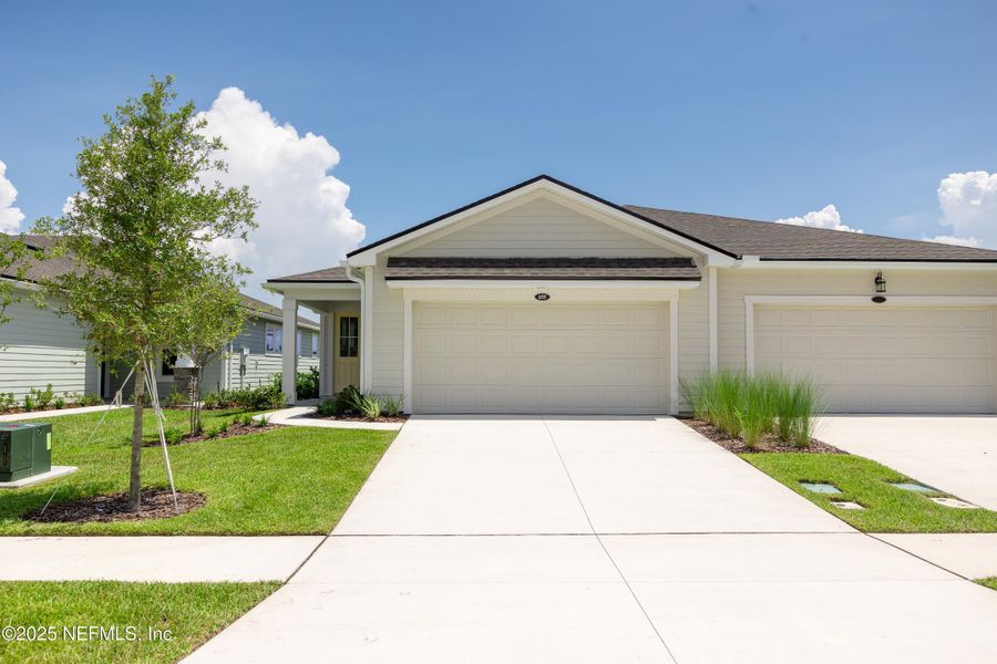 Front exterior of a new home in RiverTown - WaterSong, St. Johns, FL, highlighting curb appeal (Image 1).