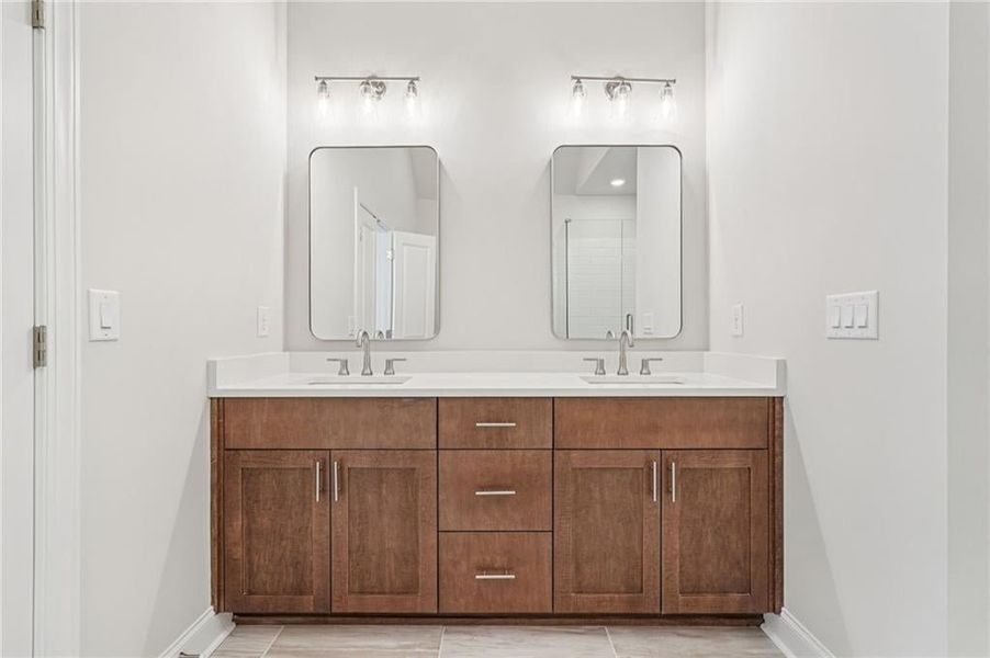 Full bath with double vanity and baseboards