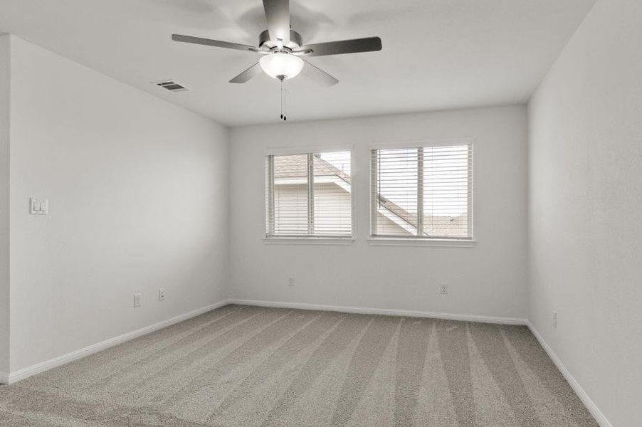 Empty room featuring light carpet and ceiling fan Empty room featuring light carpet and ceiling fan