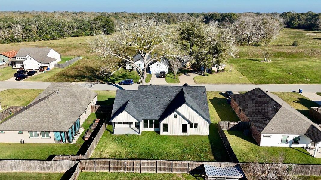 This aerial photo showcases a charming suburban home with a modern design, featuring a spacious backyard enclosed by a privacy wooden fence. Surrounded by well-maintained neighboring houses, it's situated in a quiet, green area with ample open space nearby, offering a peaceful environment. This aerial photo showcases a charming suburban home with a modern design, featuring a spacious backyard enclosed by a privacy wooden fence. Surrounded by well-maintained neighboring houses, it's situated in a quiet, green area with ample open space nearby, offering a peaceful environment.