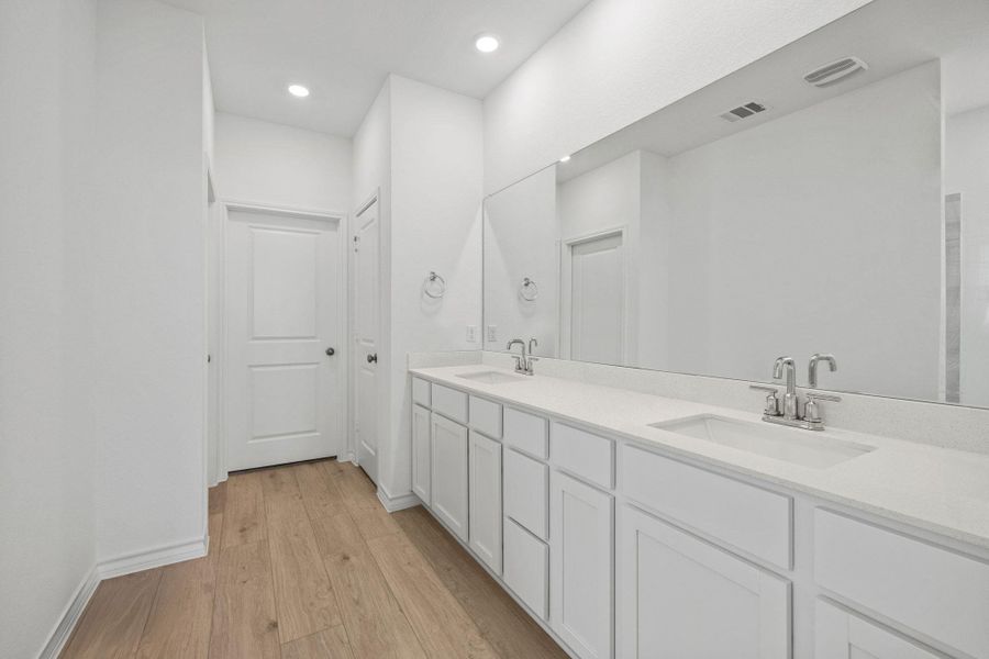 Full bath with light wood-style flooring, double vanity, and recessed lighting
