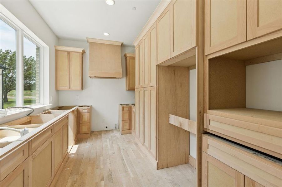 The prep kitchen is a full second kitchen with a gas range, oven, dishwasher, refrigerator, microwave, separate ventilation system, and pantry cabinets.