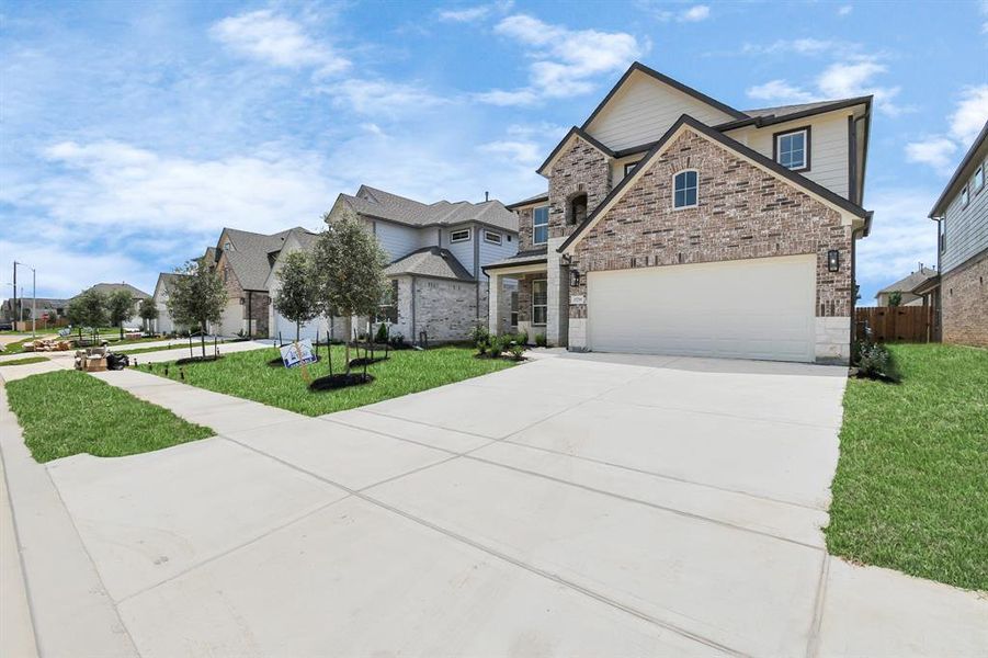 The residence features a practical 2-car garage complemented by a generous driveway, ensuring abundant space for parking needs.