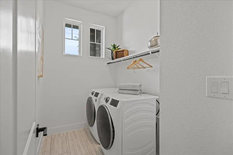 Laundry room featuring separate washer and dryer and baseboards Laundry room featuring separate washer and dryer and baseboards