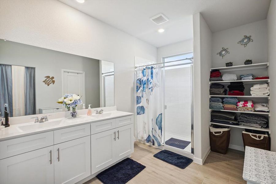 Bathroom with walk in shower, hardwood / wood-style floors, and dual bowl vanity Bathroom with walk in shower, hardwood / wood-style floors, and dual bowl vanity