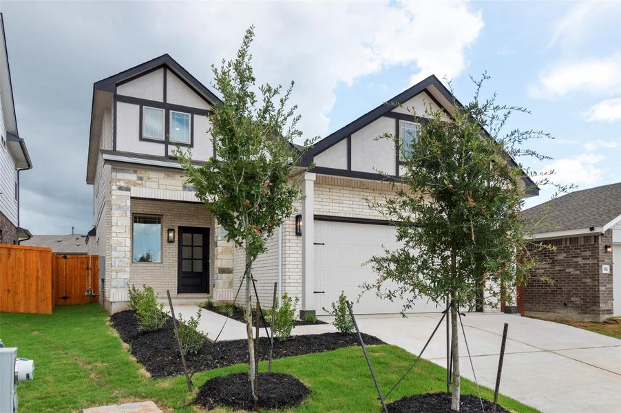 English style home featuring brick siding, concrete driveway, and an attached garage English style home featuring brick siding, concrete driveway, and an attached garage