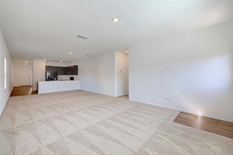 Unfurnished living room featuring recessed lighting and light colored carpet