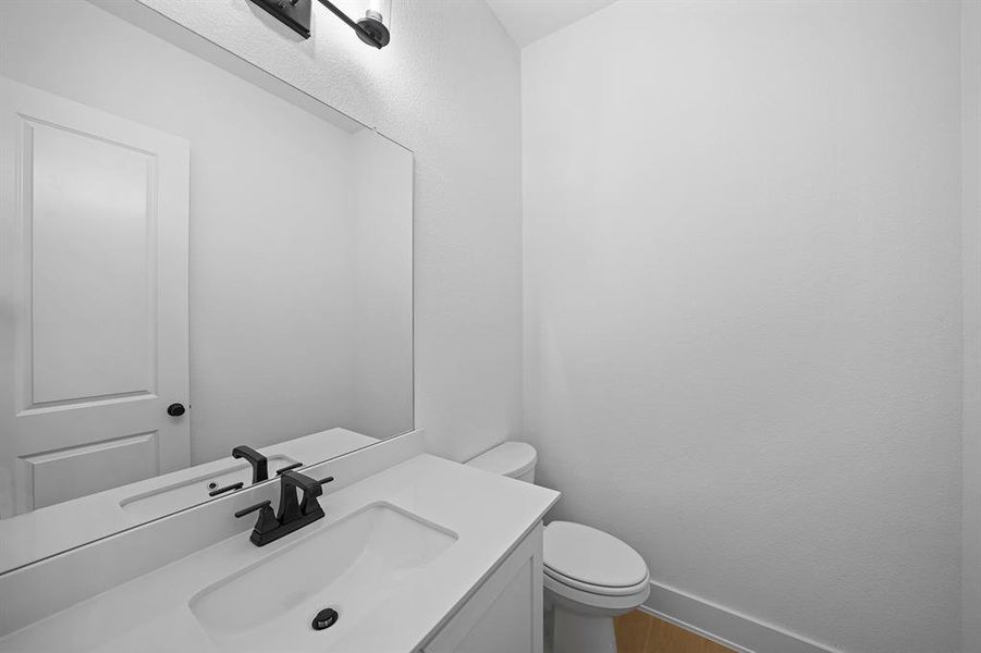 Half bath featuring vanity and wood finished floors