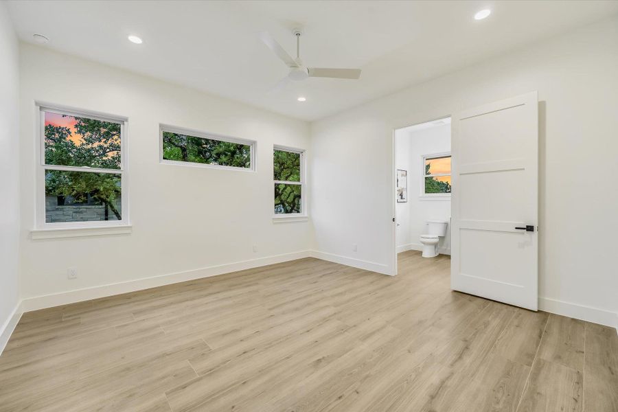 Unfurnished bedroom featuring ceiling fan, light wood-type flooring, recessed lighting, and ensuite bathroom