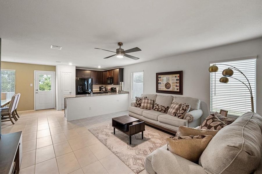 Living area with light tile patterned floors and ceiling fan