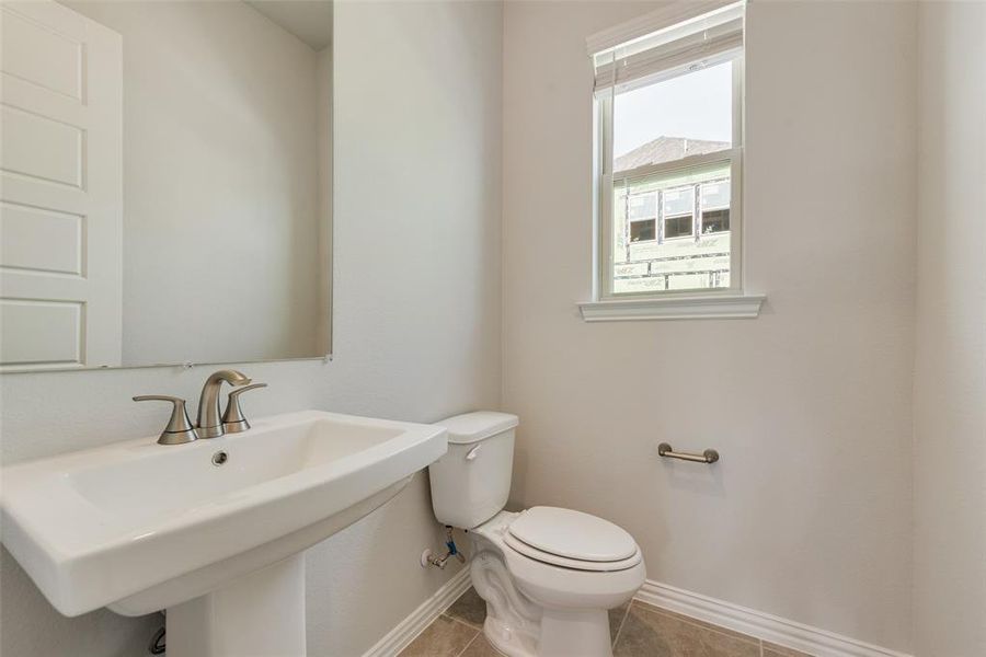 Bathroom with tile patterned floors, sink, and toilet