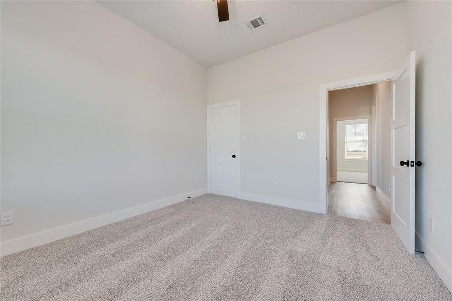 Empty room featuring ceiling fan and light colored carpet