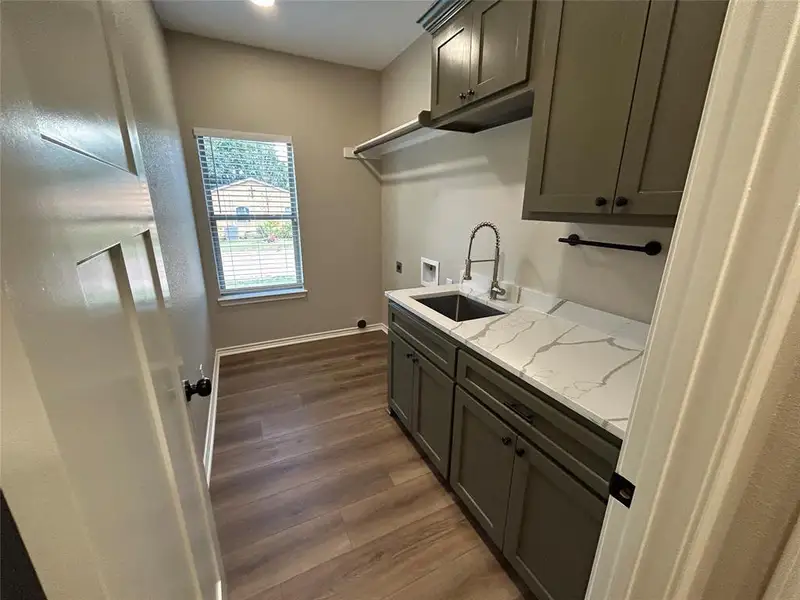 Laundry area with cabinet space, dark wood finished floors, washer hookup, and hookup for an electric dryer