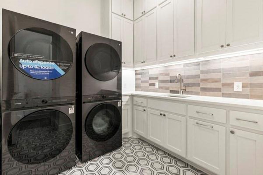 Laundry area featuring cabinet space and stacked washing machine and dryer Laundry area featuring cabinet space and stacked washing machine and dryer