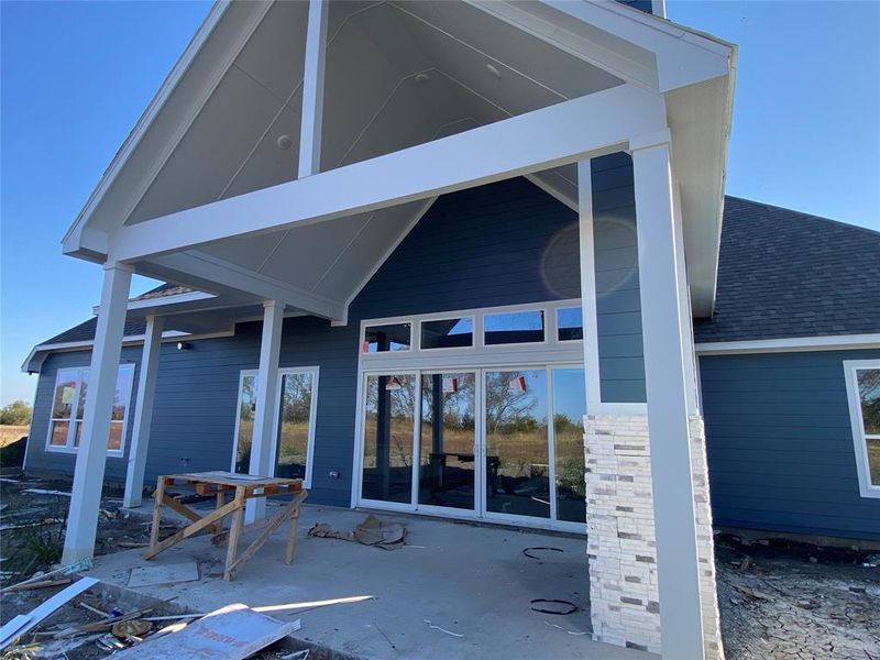Back of house featuring roof with shingles and a patio Back of house featuring roof with shingles and a patio
