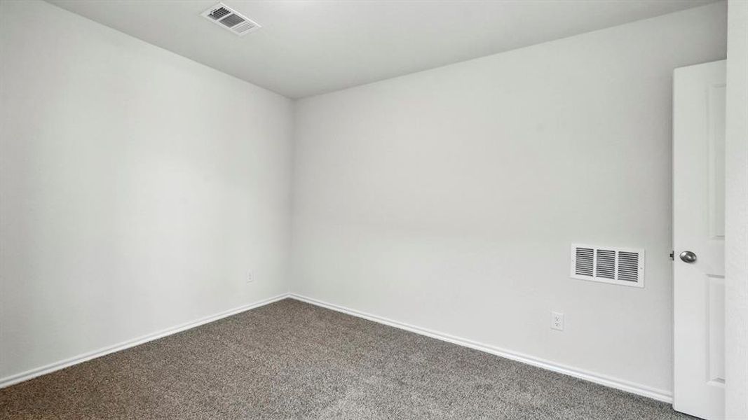 Room featuring light-colored walls, gray carpet, and white trim