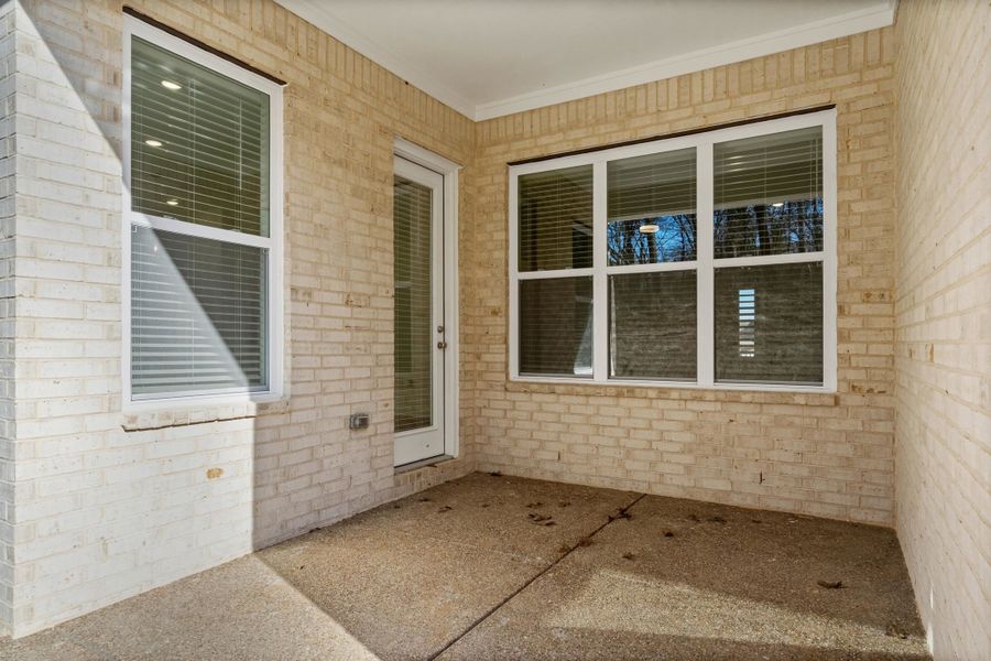 Property entrance with brick siding and a patio