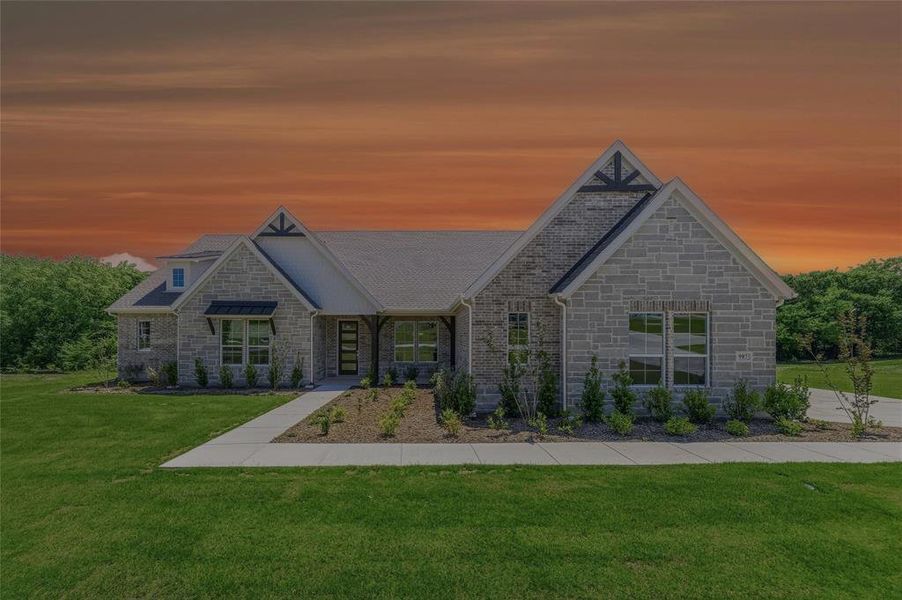 Stone facade residence featuring multiple gables, a dark shingle roof, and a covered entry