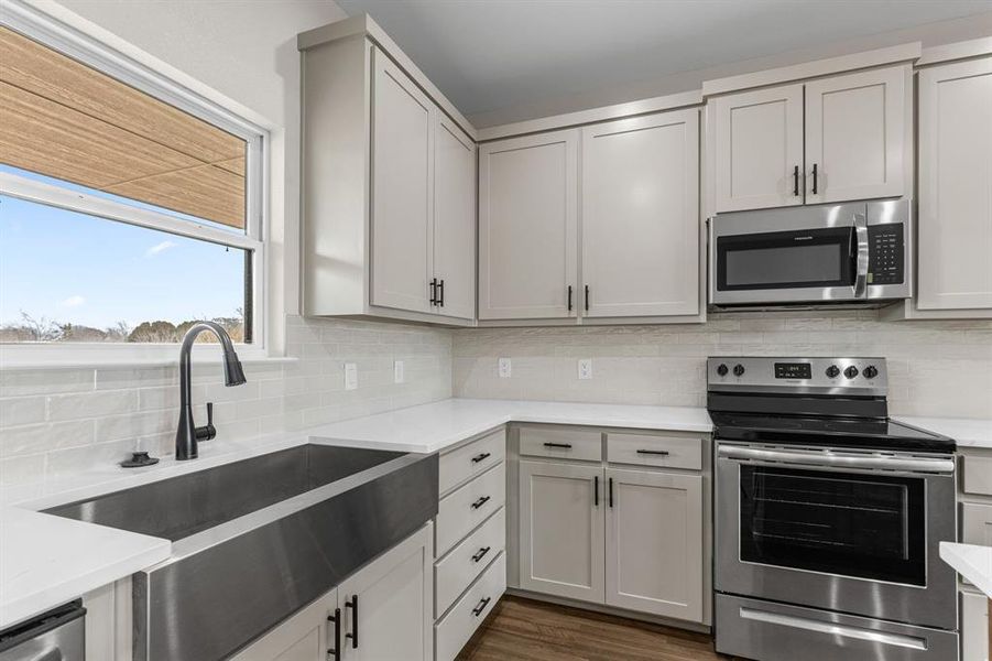 Kitchen featuring tasteful backsplash, stainless steel appliances, dark hardwood / wood-style flooring, and sink Kitchen featuring tasteful backsplash, stainless steel appliances, dark hardwood / wood-style flooring, and sink