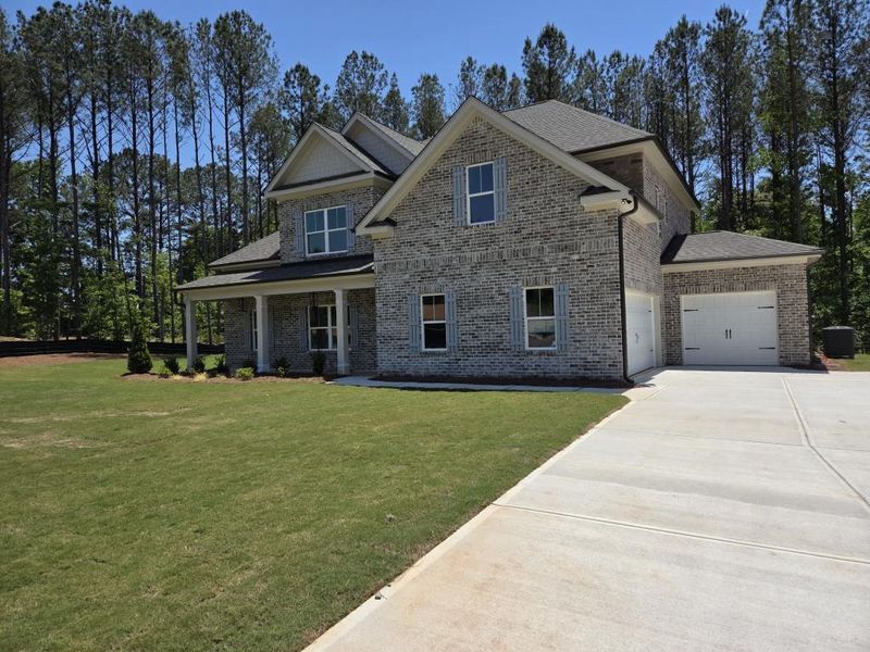 Front exterior of a new home in Palm Springs Manor Create Homes, Ellenwood, GA, highlighting curb appeal (Image 13).