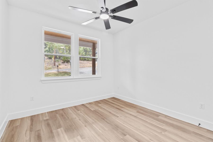 Spare room with light wood finished floors and ceiling fan