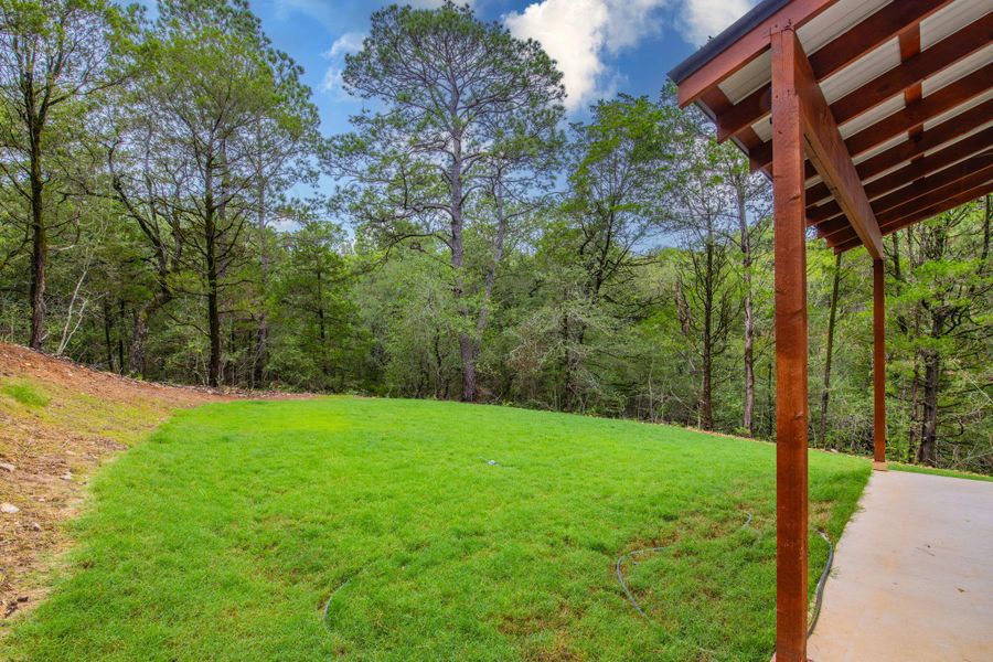 A spacious backyard unfolds into a verdant forest, perfect for tranquil outdoor living. A spacious backyard unfolds into a verdant forest, perfect for tranquil outdoor living.