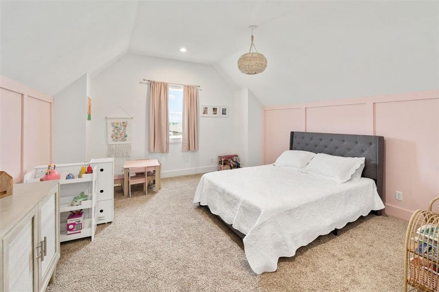 Bedroom with light colored carpet and lofted ceiling