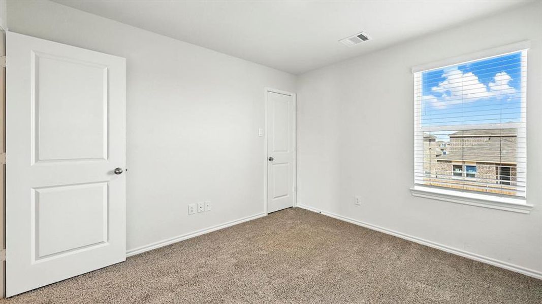 Carpeted room featuring white walls, a single window with blinds, and two panel doors