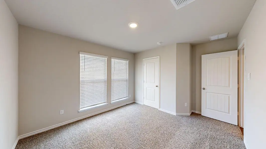 Unfurnished bedroom featuring baseboards and light carpet