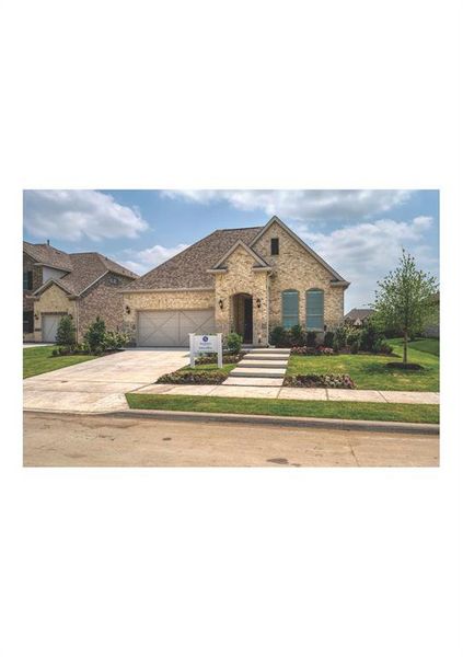 View of front of home featuring a front yard and a garage