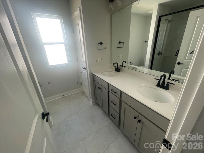 Dual sinks and drawer bank with walk in shower, linen closet in Primary Bath