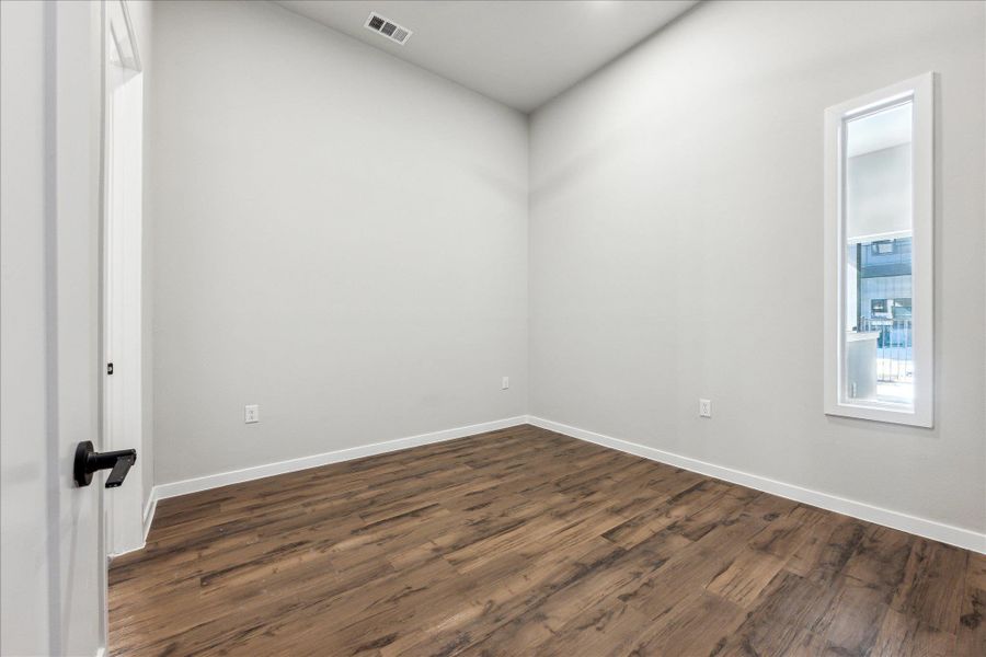 Rich hardwood-style flooring and a slender window define this versatile space. Rich hardwood-style flooring and a slender window define this versatile space.