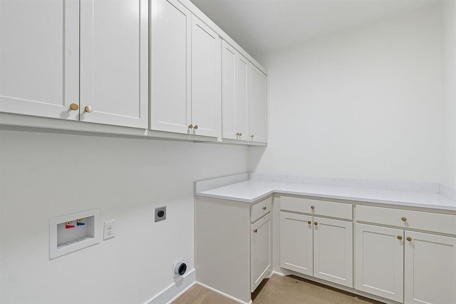 Washroom with cabinet space, hookup for an electric dryer, and hookup for a washing machine
