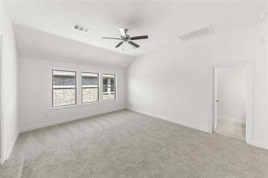 Unfurnished room with light colored carpet, ceiling fan, and lofted ceiling