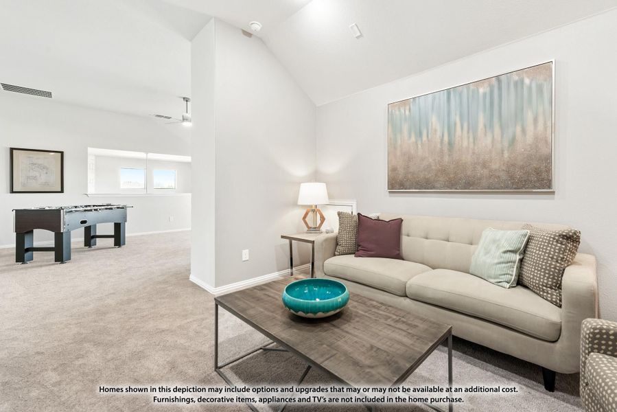 Bonus room with vaulted ceiling, sofa, coffee table, and foosball table in background