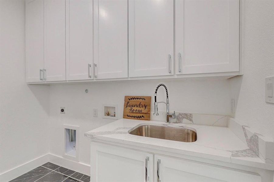 Laundry room featuring cabinets, sink, electric dryer hookup, and washer hookup