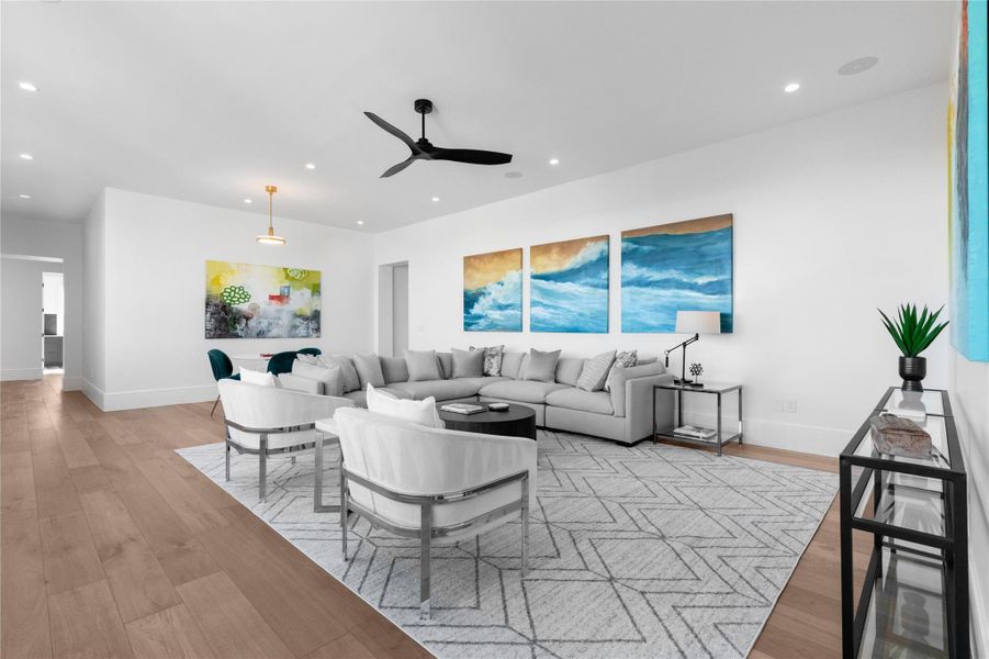 Living room with a ceiling fan, light wood-style flooring, and recessed lighting Living room with a ceiling fan, light wood-style flooring, and recessed lighting